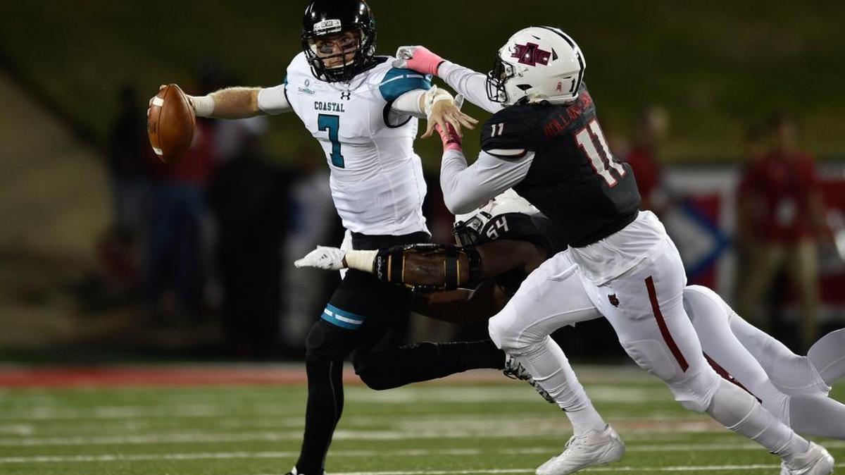 Coastal Carolina quarterback Kilton Anderson is chased by Arkansas State defensive end Ja’Von Rolland-Jones, who knocked starting quarterback Tyler Keane out of the game with a sack in the Red Wolves’ 51-17 win Saturday night in Jonesboro, Ark.