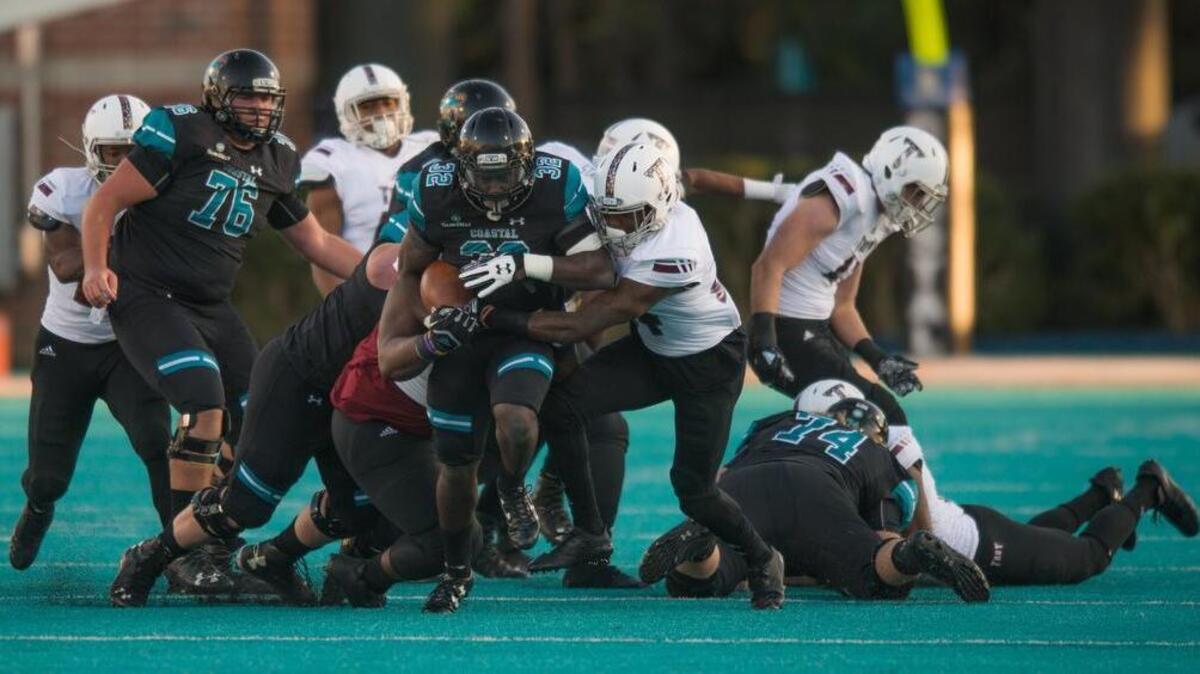 Osharmar Abercrombie runs through a hole created by Coastal Carolina’s young offensive line against Troy on Saturday at Brooks Stadium.