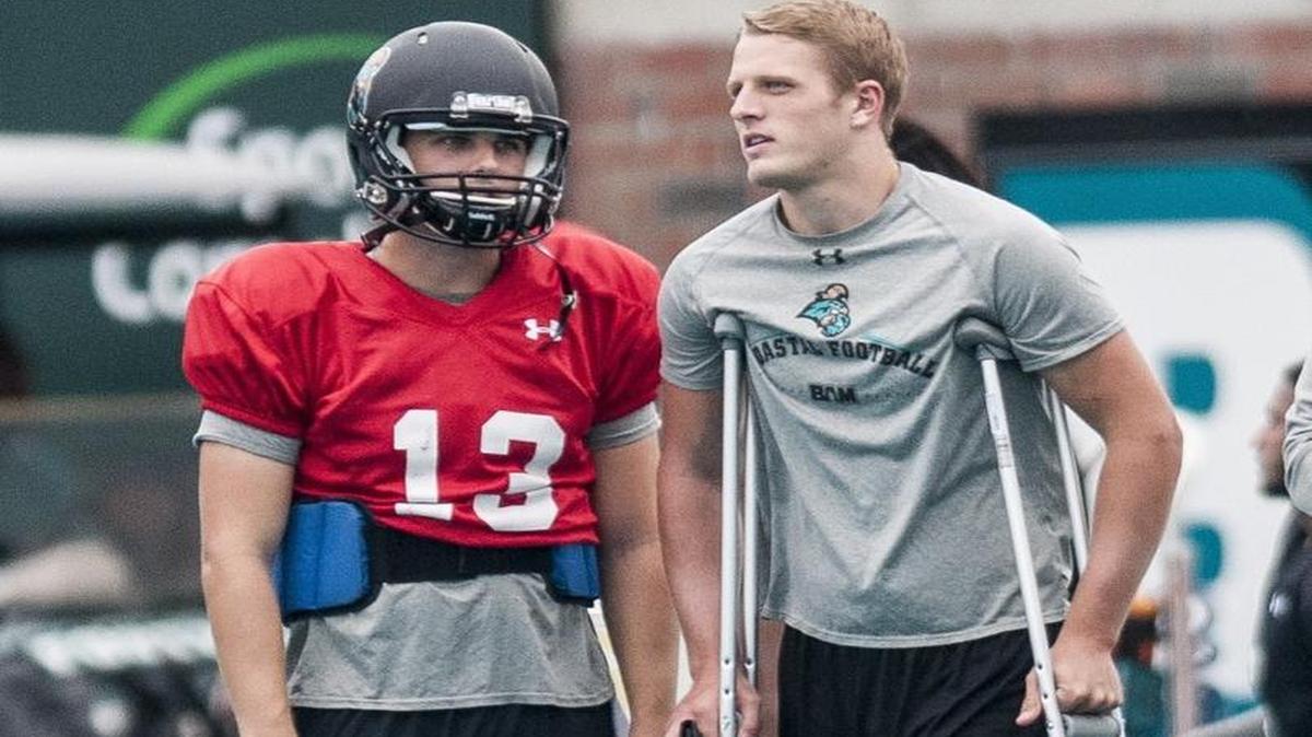 Coastal Carolina’s Tyler Keane (left) talks with injured quarterback Josh Stilley during practice on Tuesday.