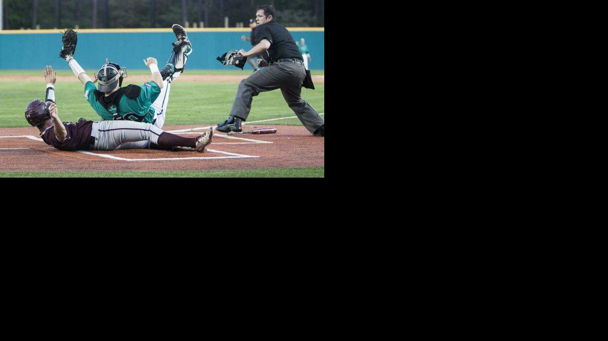 
Coastal Carolina catcher Casey Schroeder (top) tags out College of Charleston’s Erven Roper at home plate. 
