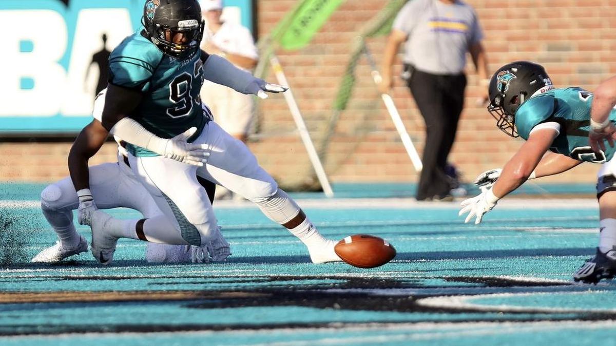 Coastal Carolina’s Alex Scearce (right) recovers a fumble in the game during a game last season.