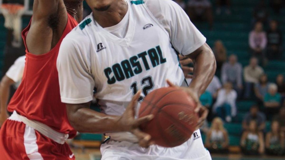 Coastal Carolina’s Michel Enanga gets past Radford’s Ed Polite Jr. during Sunday’s game.