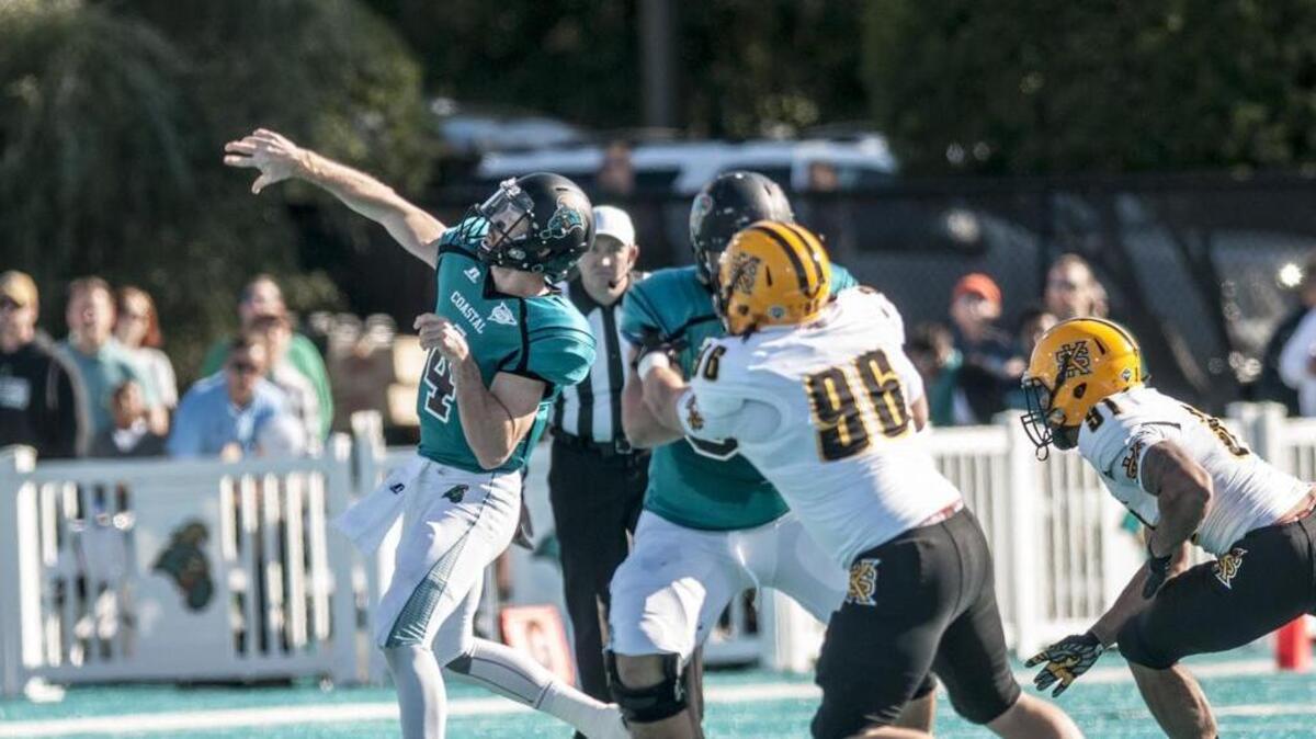 Coastal Carolina quarterback Alex Ross (left) throws a long pass during Saturday’s game against Kennesaw State.