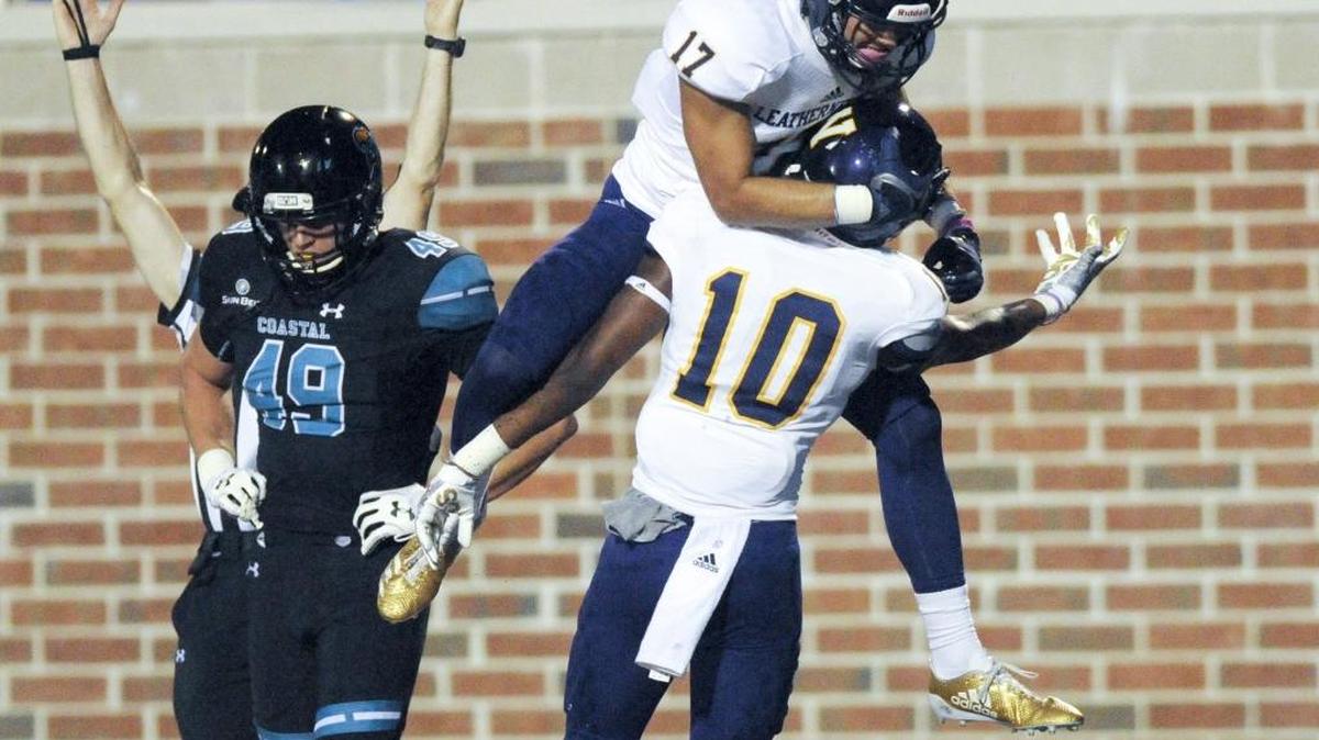 Western Illinois’ Jaelon Acklin and Brandon Gaston celebrate a touchdown in front of Coastal Carolina junior linebacker James Heft. Western Illinois defeated CCU 52-10 at Brooks Stadium on Saturday.