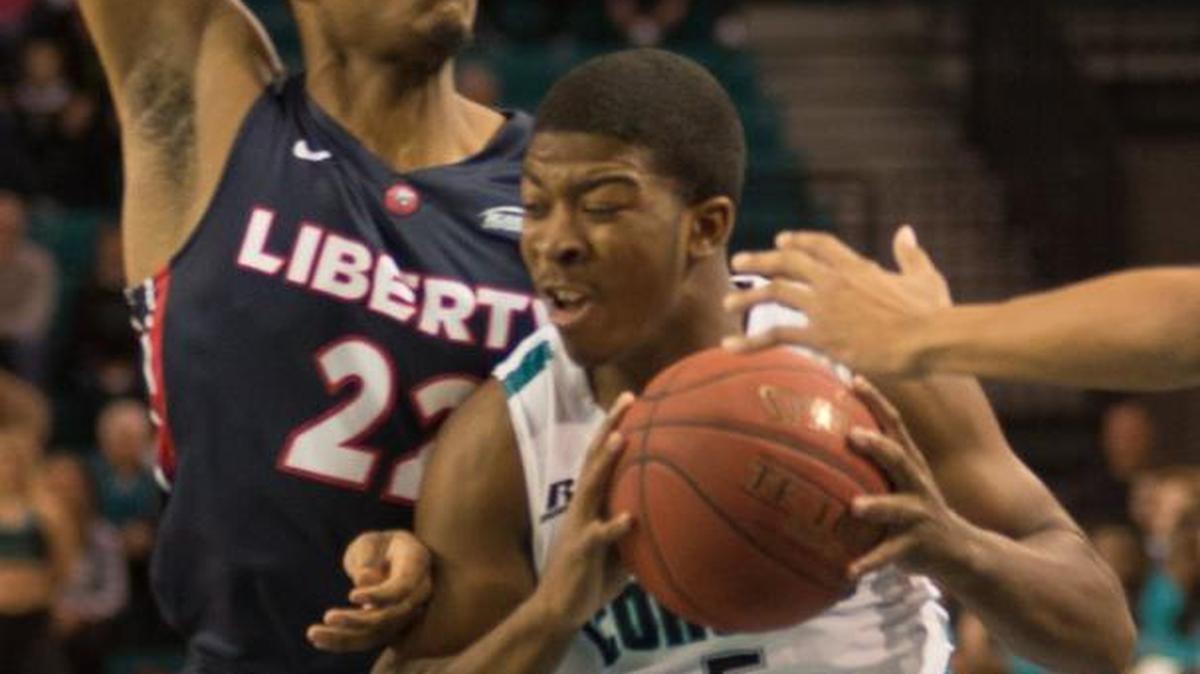 Coastal Carolina’s Jaylen Shaw absorbs contact by Liberty’s John Dawson during Wednesday night’s game.