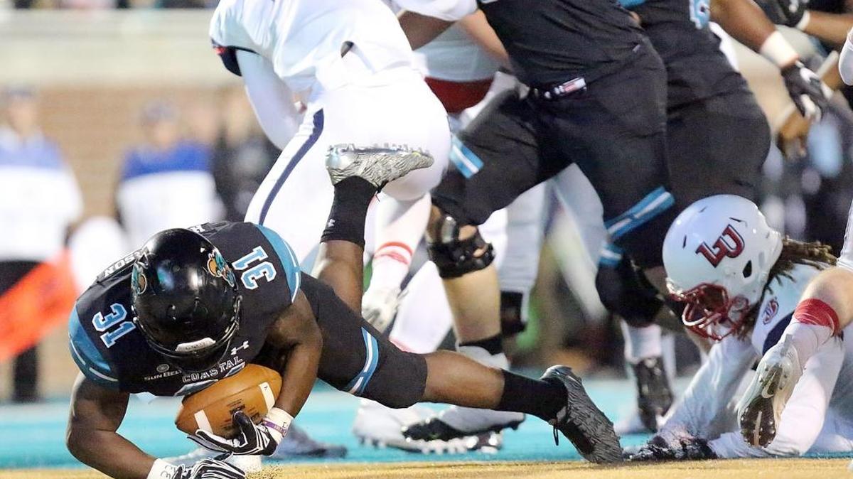 Coastal Carolina University's De'Angelo Henderson scores the first of his two touchdowns in the first half of the game with Liberty University on Thursday, Nov. 17, 2016. He has scored a touchdown in an NCAA Division 1-record 34 straight games.