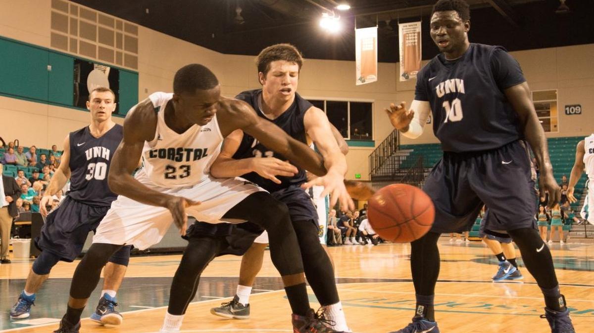 Coastal Carolina’s Badou Diagne (23) hauls in a rebound over New Hampshire’s Tanner Leissner during Saturday’s game.