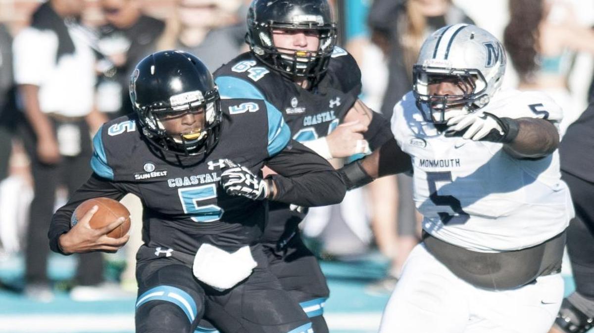 Coastal Carolina quarterback Austin Bradley, left, sneaks the ball against Monmouth on Saturday.