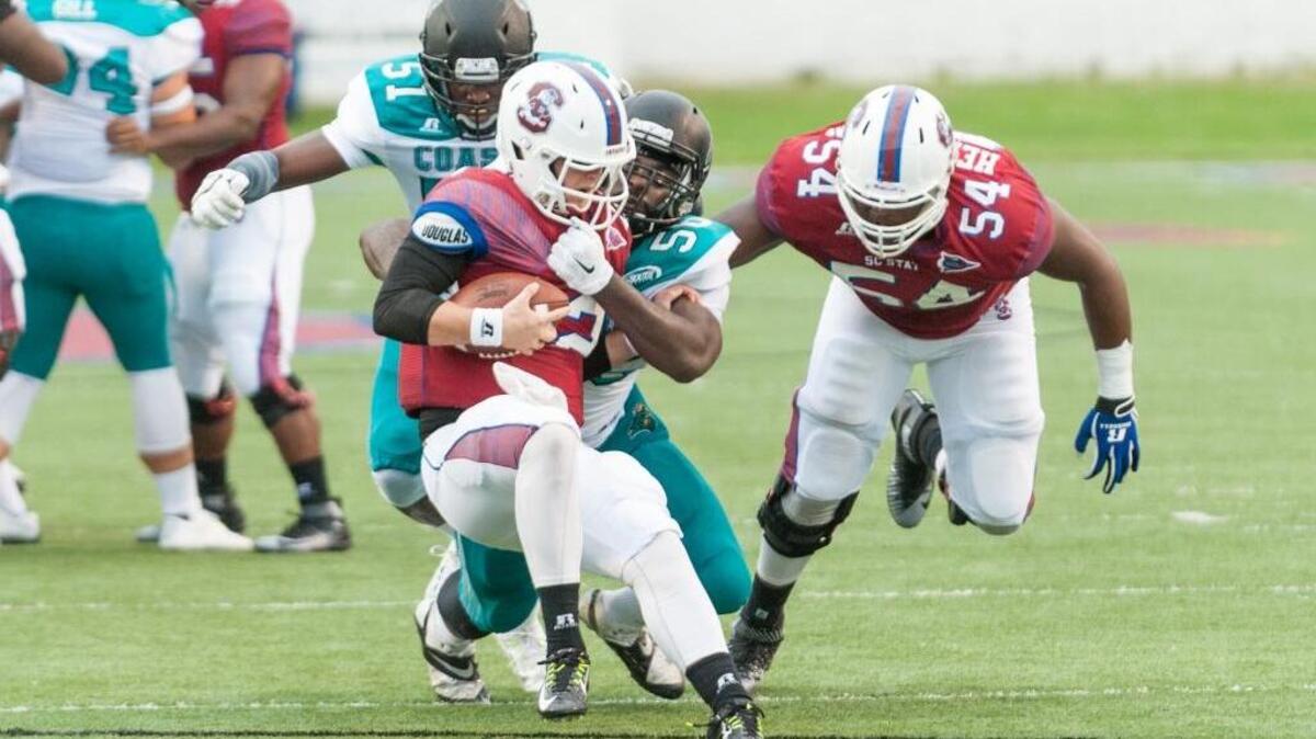 
Coastal Carolina’s Aaron McFarland (center) makes a tackle against South Carolina State.
