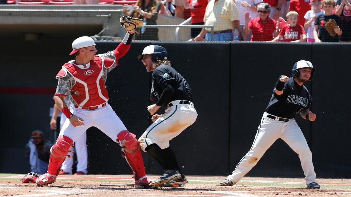 Coastal Carolina’s Zach Remillard (center) celebrates with teammate Michael Paez after scoring on a hit by Seth Lancaster in the ninth inning.