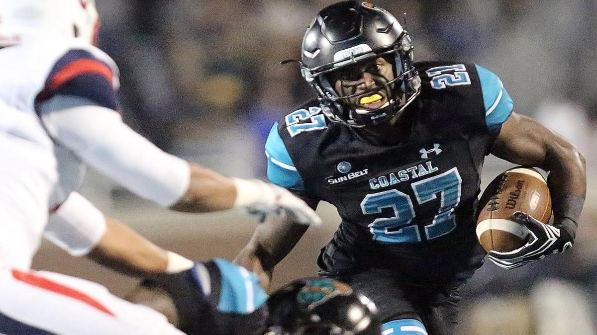 Coastal Carolina’s Devin Brown looks for running room against Liberty on Thursday.
