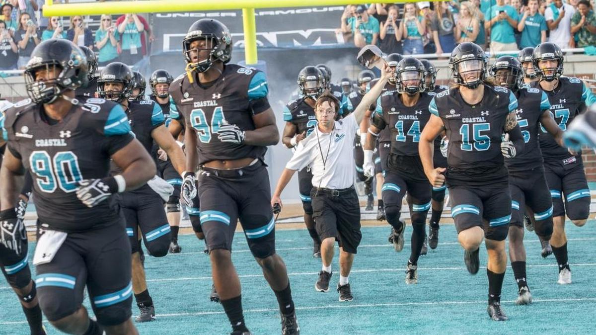Coastal Carolina players run onto the field at Brooks Stadium on Saturday for their game against Western Illinois several minutes after the singing of the national anthem.