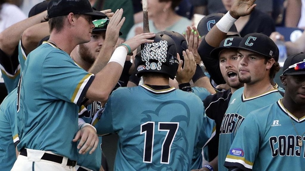 Coastal Carolina's Billy Cooke (17) celebrates with teammates after scoring on a Anthony Marks two-run single against Arizona in the third inning in Game 2 of the NCAA Men's College World Series finals baseball game in Omaha, Neb., Tuesday, June 28, 2016.