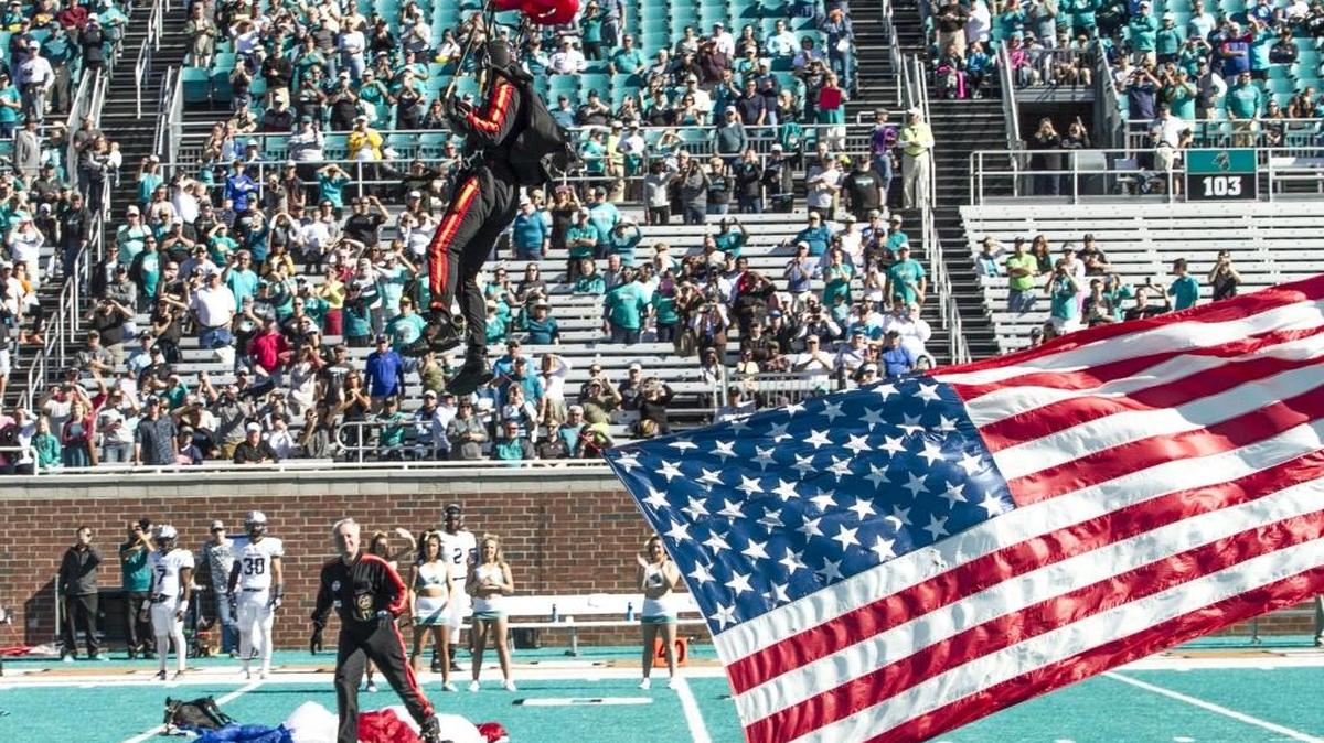 Retired Army jumpers bring in the flags and game ball to Brooks Stadium before Coastal Carolina’s game against Monmouth on Saturday.