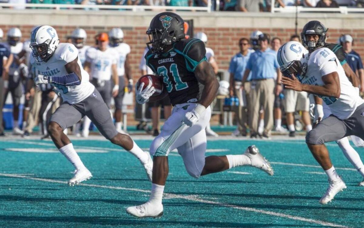 Coastal Carolina’s DeAngelo Henderson (center) runs for a touchdown against The Citadel.