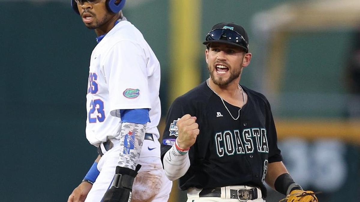 Coastal Carolina's Tyler Chadwick (8), right, celebrates after making a double play on second base, forcing out Florida's Buddy Reed (23) in the bottom of the sixth inning.