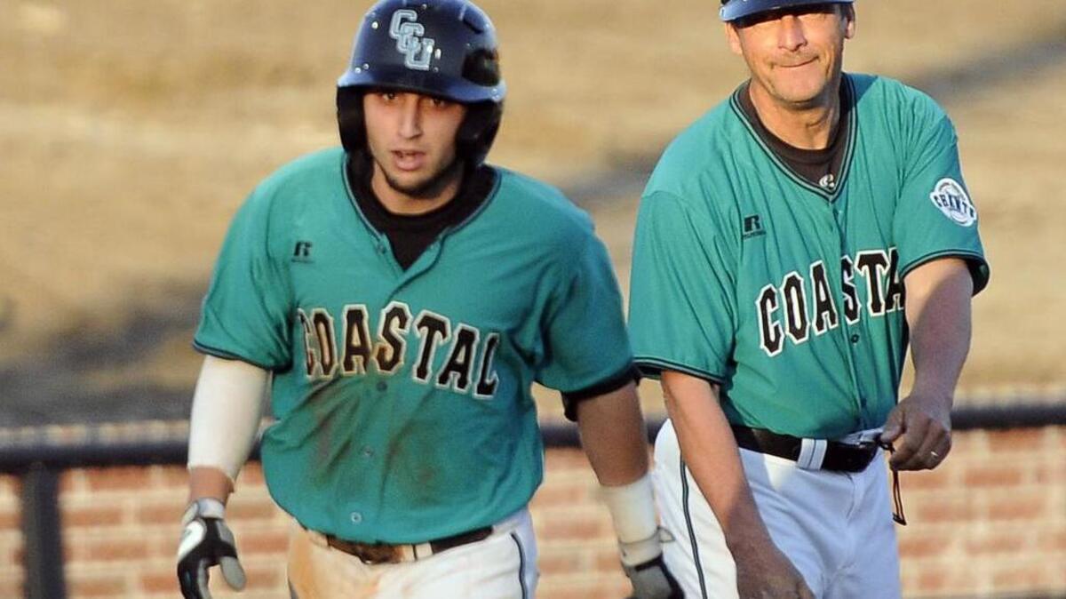 Coastal Carolina head coach, Gary Gilmore (right) smiles as shortstop Michael Paez rounds third after hitting a solo home run during a game last year. The Chanticleers have pieced together a tough 2016 schedule stacked with premier opponents.