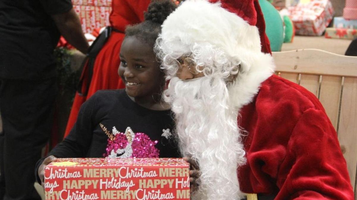 Josh Norman, dressed as Santa, handed out presents to the hundreds of children gathered Monday night at Morris Chapel Baptist Church in Greenwood.
