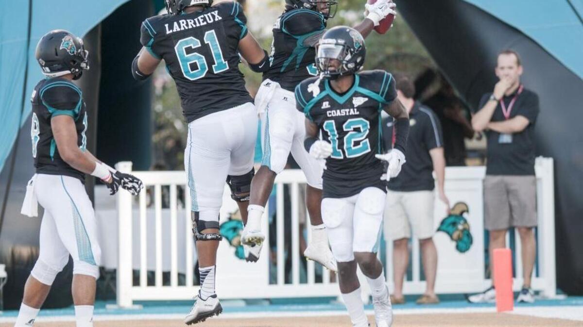 Coastal Carolina’s DeAngelo Henderson (top) celebrates with teammates during last week’s win over Gardner-Webb.