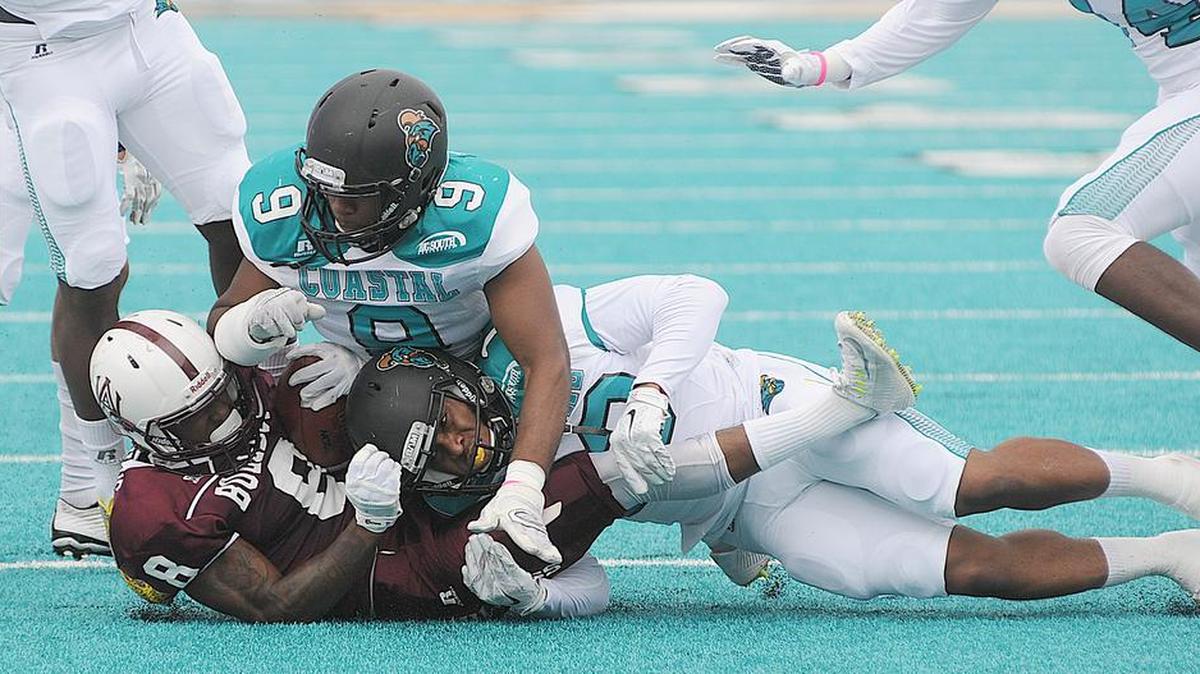 
Alabama A&M’s Octayvious Miles is brought down by a pair of Coastal Carolina defenders. 
