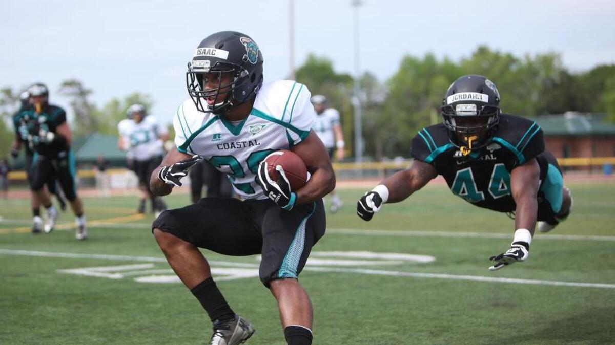 
Coastal Carolina’s Isaac Martin (left) dodges a flying tackle attempt by Jordhan Brown during the Chants’ spring game. The Sun Belt Conference has reached out to Coastal Carolina with interest in considering the Chants as a potential future member.

