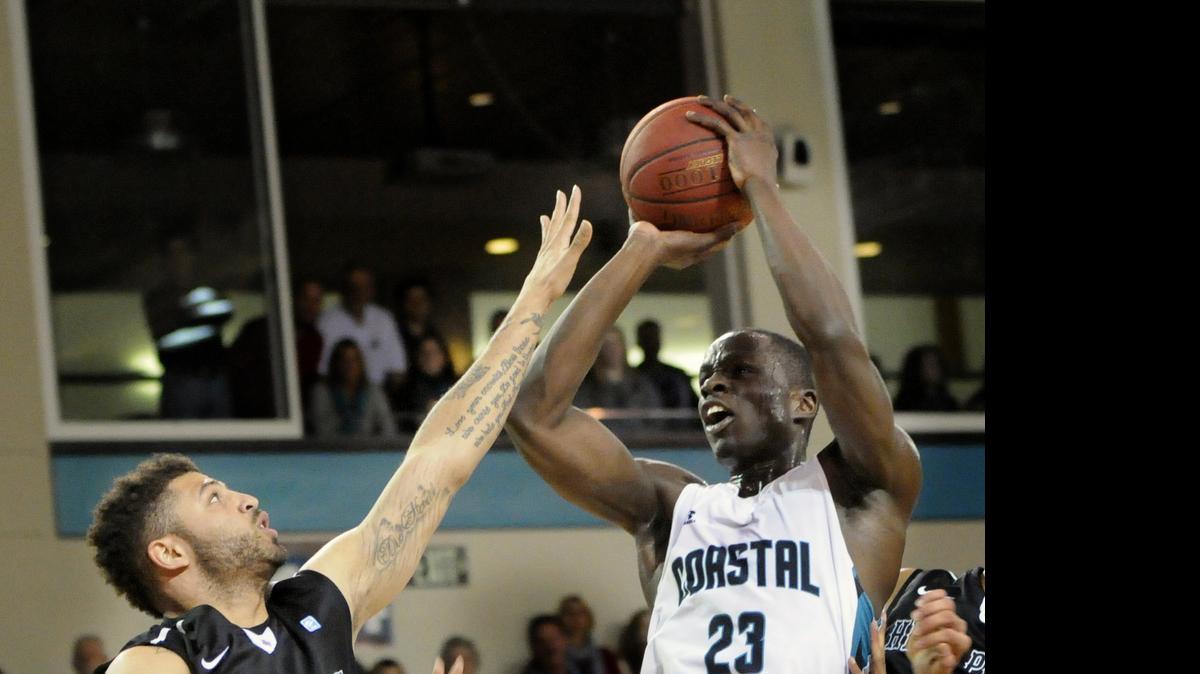 
High point guard Tarique Thompson (left) tries to block a shot by Coastal Carolina forward Badou Diagne during the first half of a game at the HTC Center. The NCAA voted in January to permit all Division I schools to provide additional money to student-athletes to cover the full “cost of attendance.” Coastal Carolina and the Big South will adopt the new COA benefits for men’s and women’s basketball players next school year.
