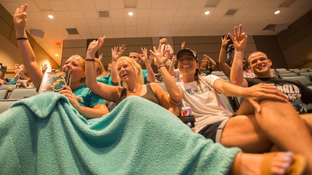 Shelby Ruschak, Emily Rossi, Beth Javener and Steve Faulk show their support for Coastal during the CCU baseball game-watching party.