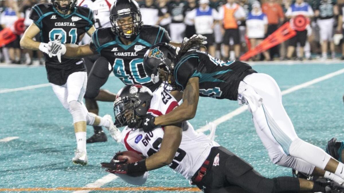 Coastal Carolina’s Michael Billings (top right) tackles Gardner-Webb’s Robert McCoy on Saturday.