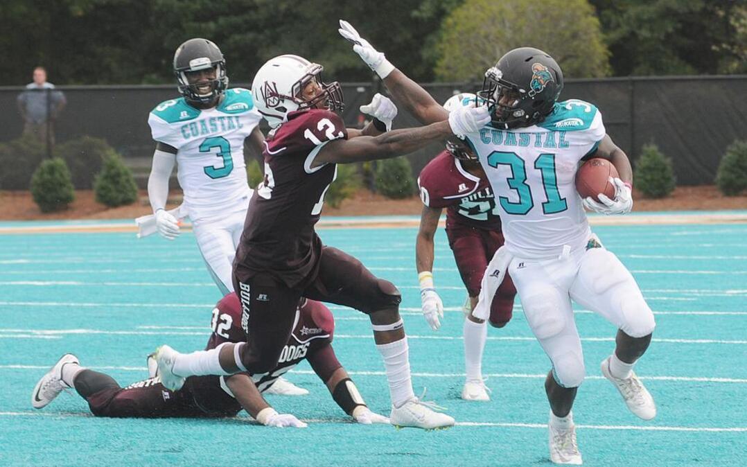 
Alabama A&M’s Devonte Simon (left) grabs the facemask of Coastal Carolina’s De’Angelo Henderson during last Saturday’s game.
