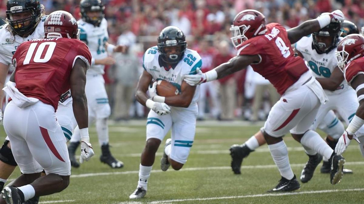 Coastal Carolina running back Alex James runs through a hole against Arkansas on Saturday.