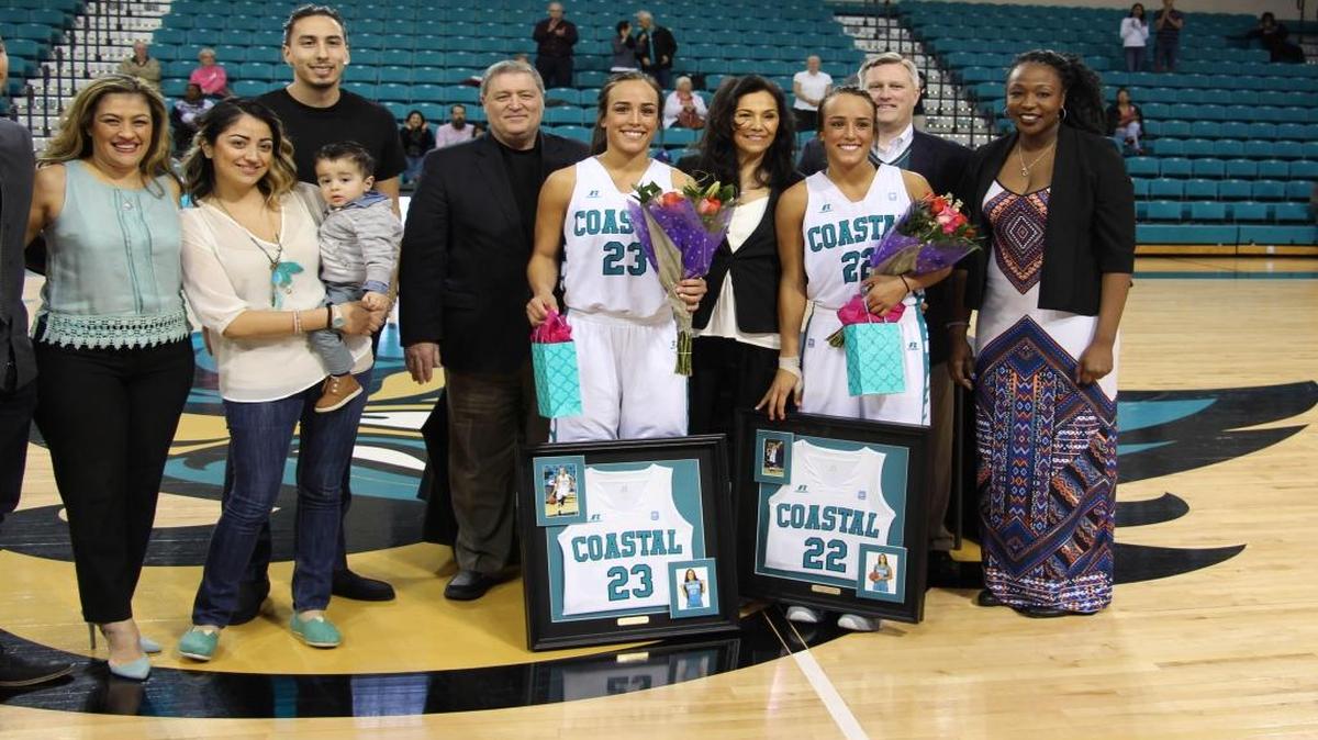 Stephanie and Nicole Isaacs are surrounded by friends and family as part of Senior Day activities at The HTC Center on Saturday.