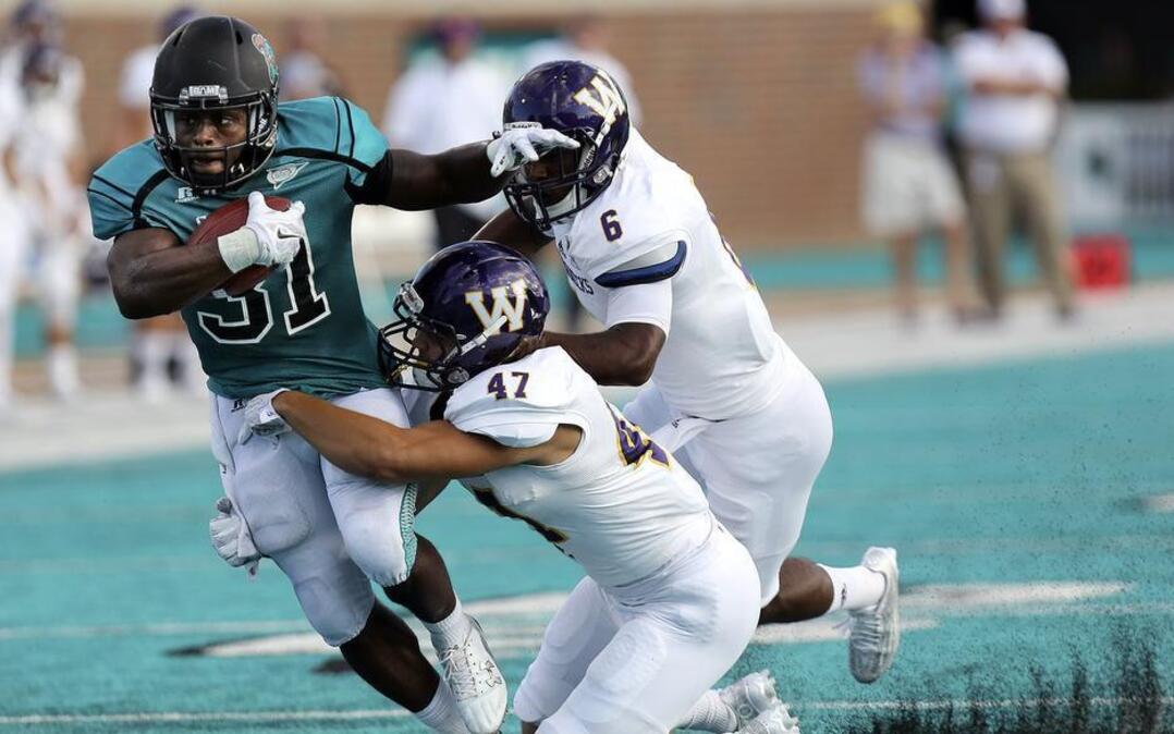 
Coastal Carolina’s De’Angelo Henderson (31) looks to get past Western Illinois tacklers Saturday.
