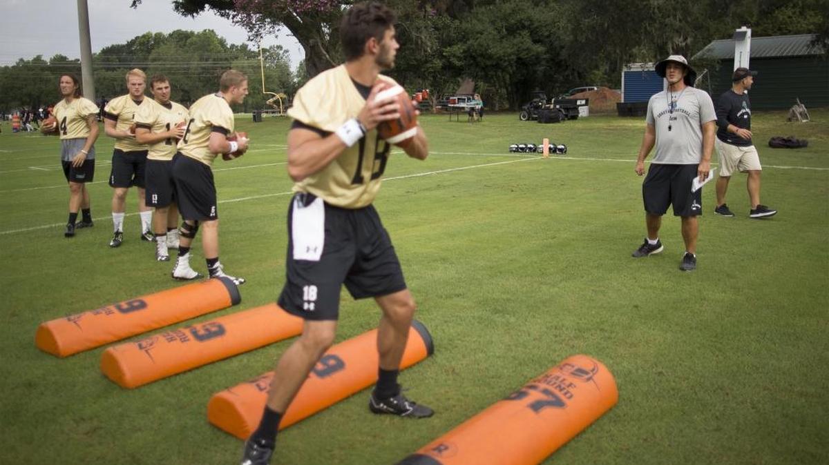 A host of quarterbacks go through drills in front of interim Coastal Carolina head coach Jamey Chadwell (right) during a preseason practice this fall. Chadwell has yet to name a starter at QB for Saturday’s season-opener against Massachusetts.