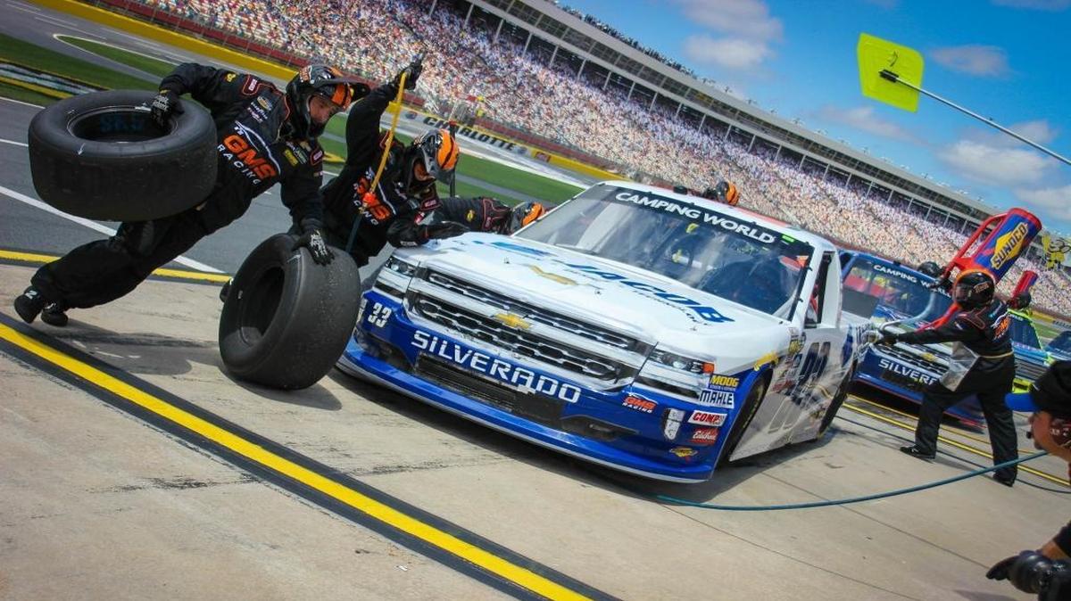Conway’s Mark Singleton (second from left) changes a tire on a Chip Ganassi Racing truck.
