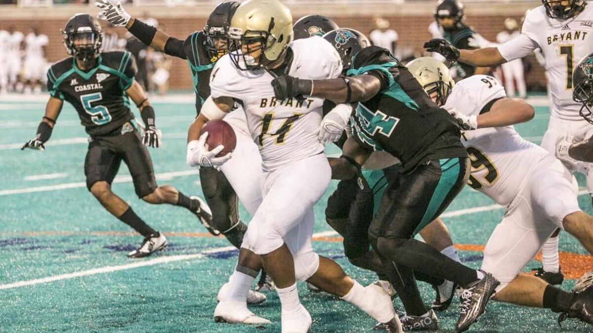 
Bryant’s Kyle Jennings tries to get away from Coastal Carolina defenders Saturday.
