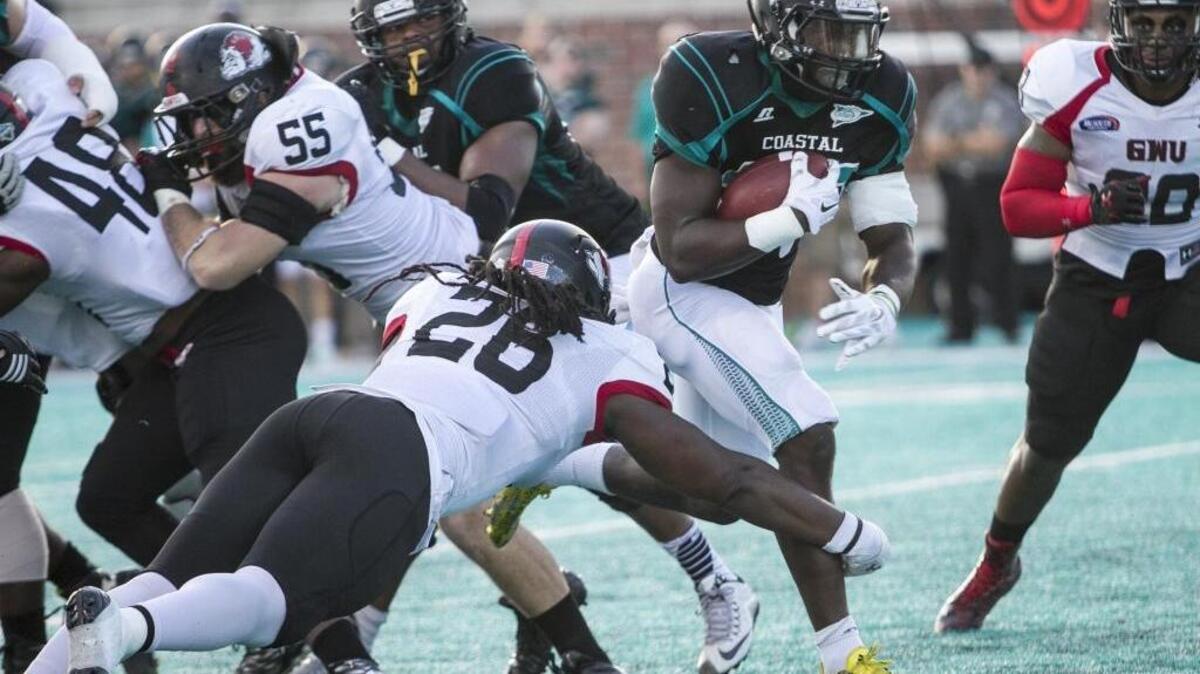 Coastal Carolina’s Osharmar Abercrombie runs past Gardner-Webb defenders for a touchdown.