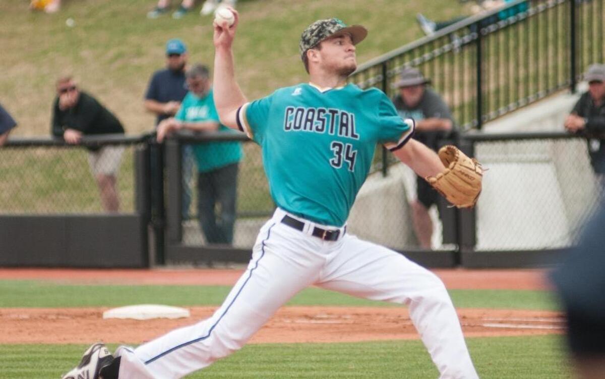 Coastal Carolina’s Cole Schaefer makes a pitch against Virginia on Sunday.