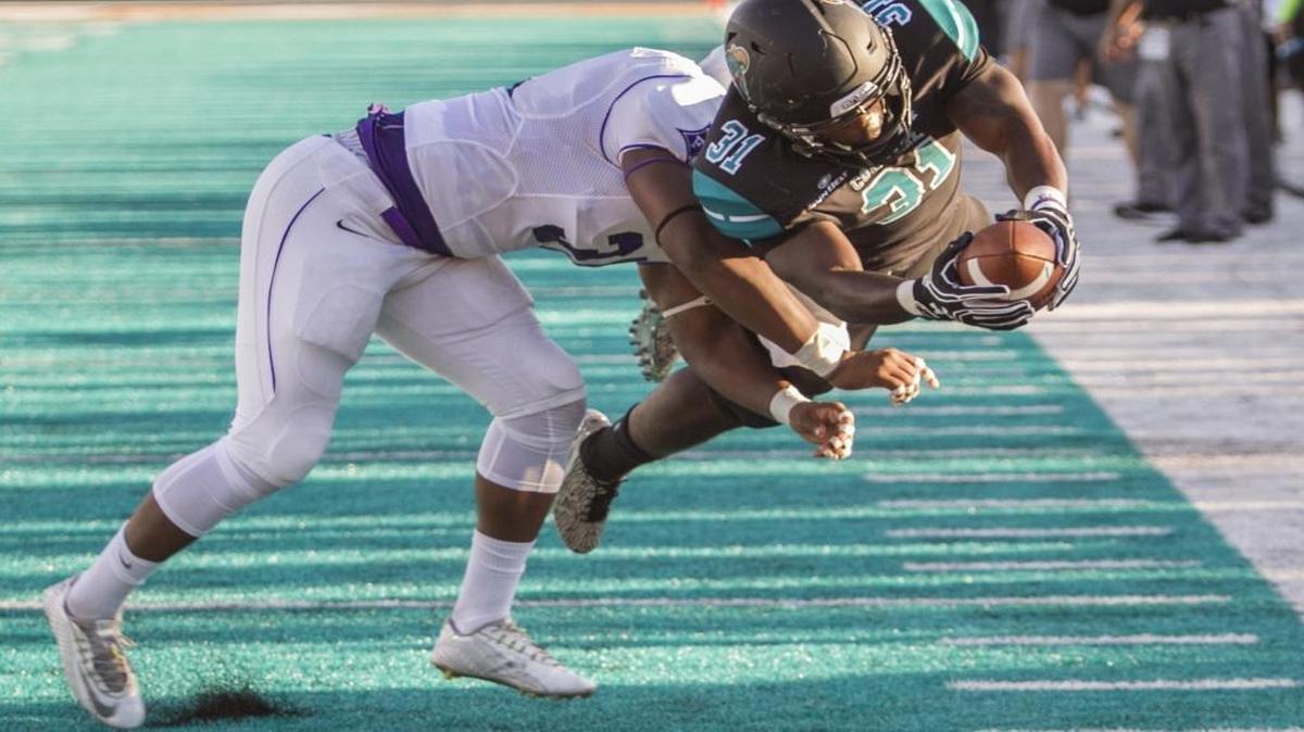 Coastal Carolina’s De’Angelo Henderson dives for a touchdown in first quarter against Furman on Saturday, extending his NCAA Division I record for most consecutive games with a touchdown to 30.