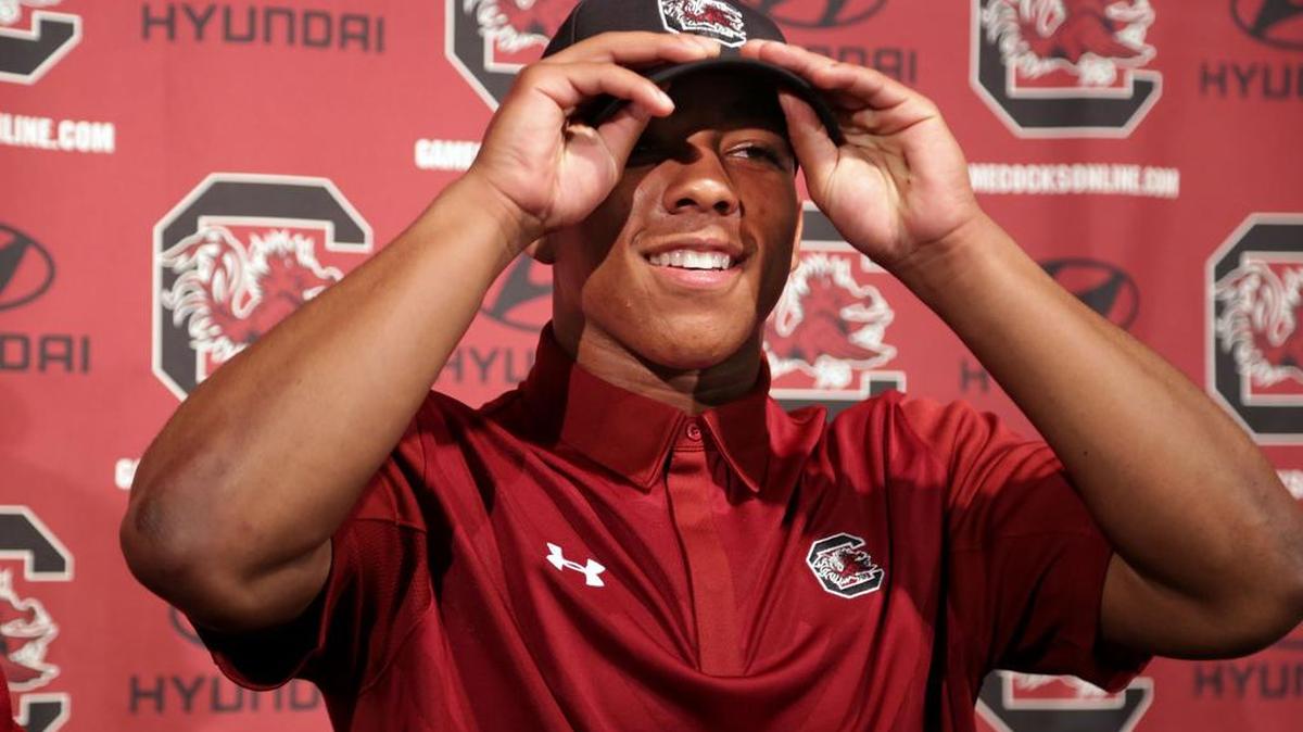 Brandon McIlwain puts on a South Carolina hat after taking part in a signing ceremony for all of the school's midyear signees, Wednesday, February 3, 2016, inside Williams-Brice Stadium.