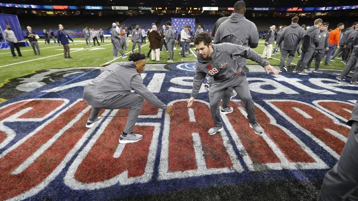 Clemson wide receiver Diondre Overton, left, and place-kicker Drew Costa low-five on the mid-field Sugar Bowl logo Saturday.