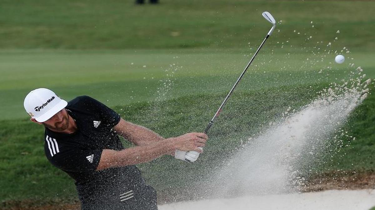 Dustin Johnson hits from a bunker on the 18th green during the third round of the Tour Championship.