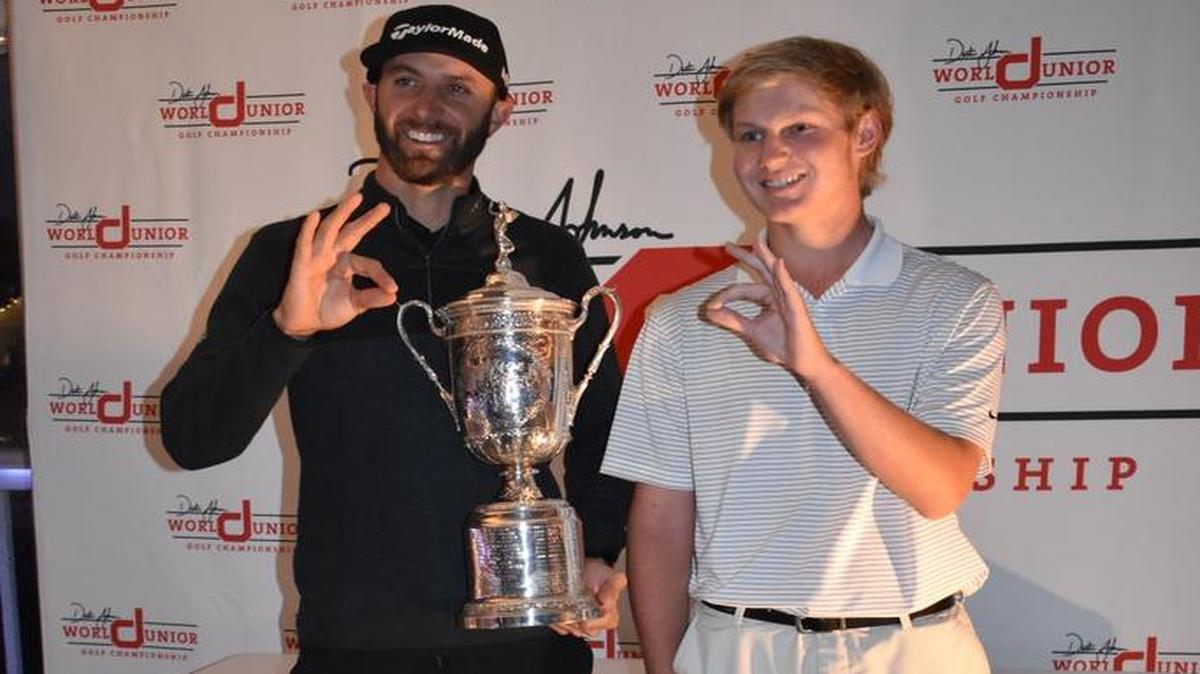 Dustin Johnson poses for a picture with Coastal Carolina commitment Tyler Gray of Lugoff and the U.S. Open trophy on the eve of the DJ World Junior Championship, and both mimic the Chanticleers logo.