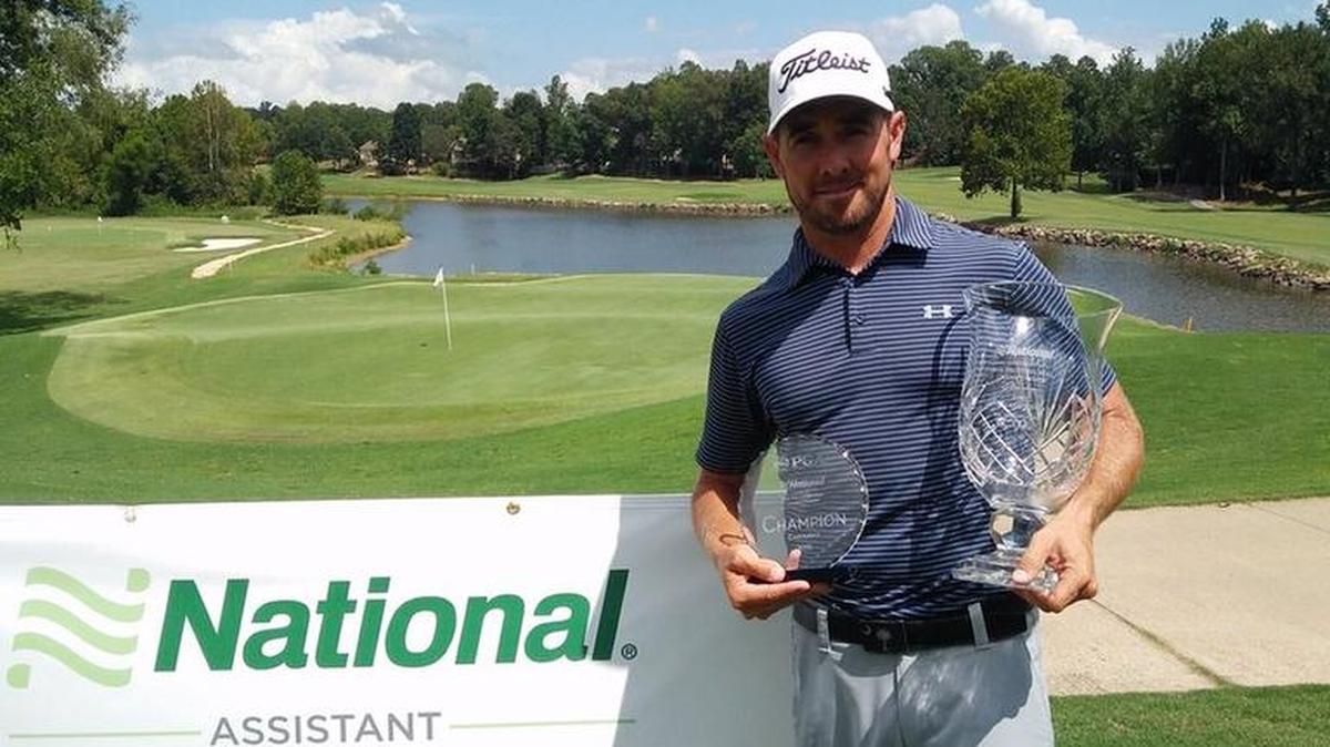 Stuart Clark holds the championship trophies Tuesday after winning the Carolinas PGA Assistant Championship.