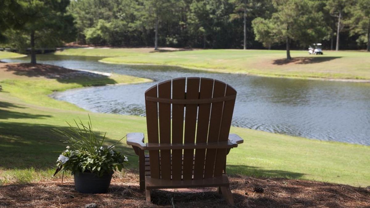 A chair in memory of Jay Varallo is positioned beside the hill top t-box of the eighth hole of the Bay 9 overlooking a lake at Sandpiper Bay.