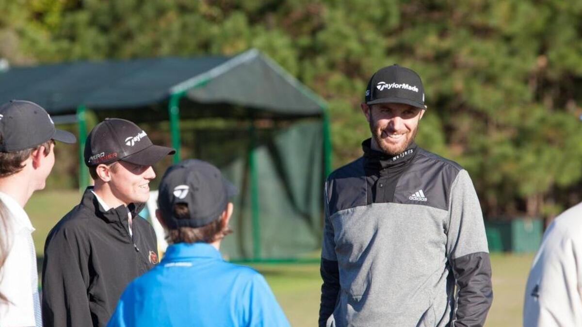PGA Tour golfer and Coastal Carolina alumnus Dustin Johnson visits with students of his golf school at the TPC of Myrtle Beach on Monday.