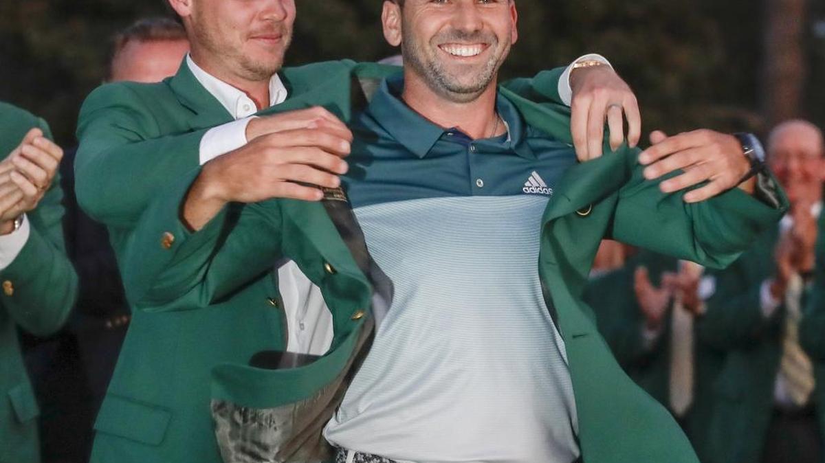 Danny Willett places the green jacket on 2017 Masters champion Sergio Garcia on the 18th green at Augusta National Golf Club on Sunday.