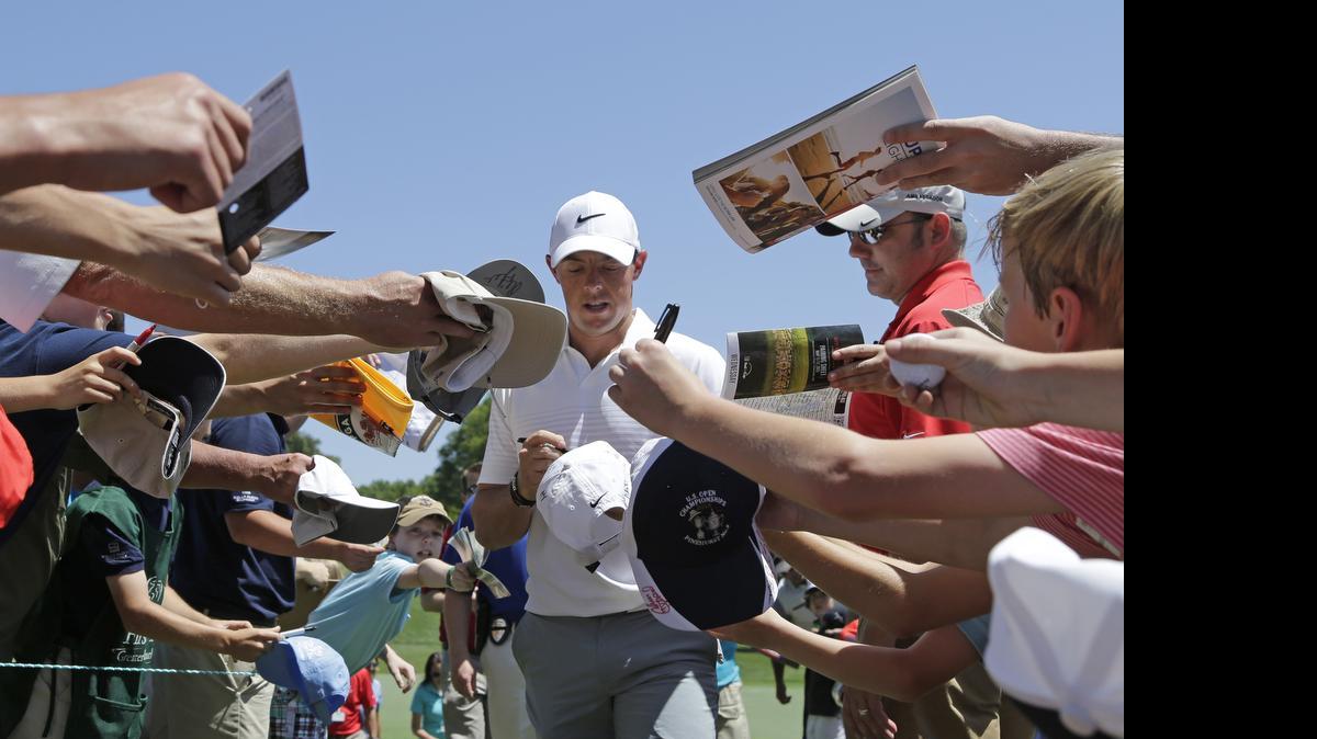 
Rory McIlroy signs autographs as he walks to the third tee during the pro-am for the Wells Fargo Championship at the Quail Hollow Club in Charlotte, N.C.
