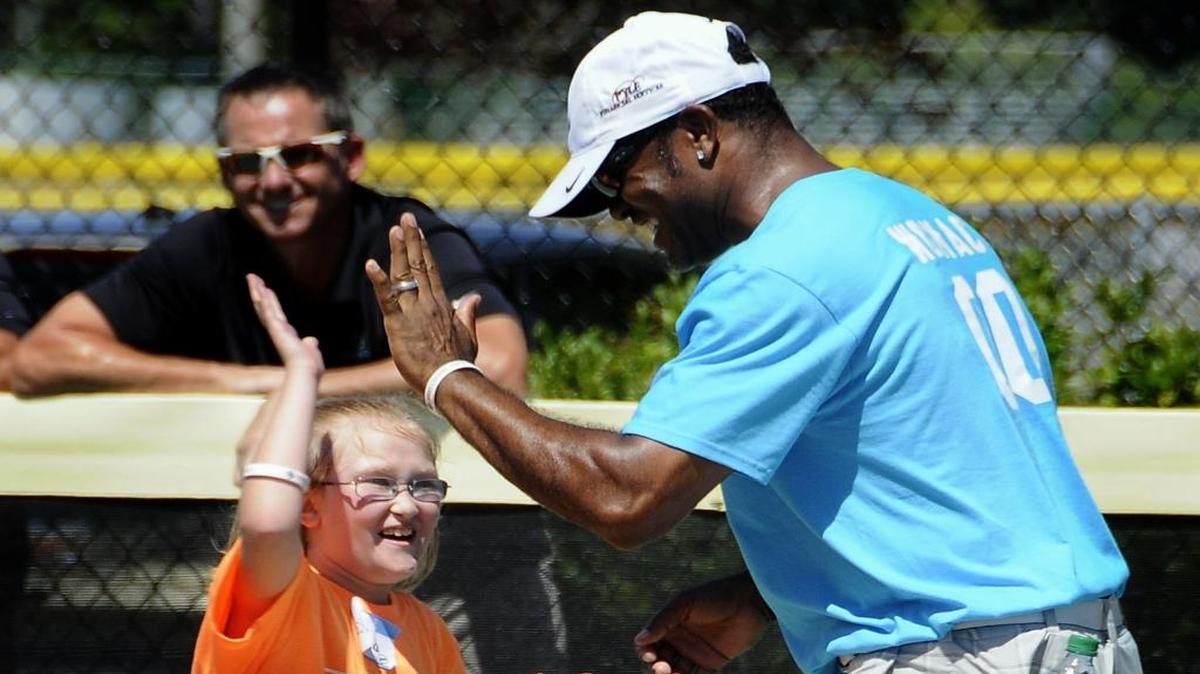 Former MLB player Tony Womack high-fives his Miracle League player partner during last year’s 2LiveBeyond festivities.
