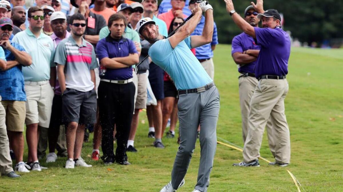 
Dustin Johnson hits from the rough on the first fairway in the Tour Championship.
