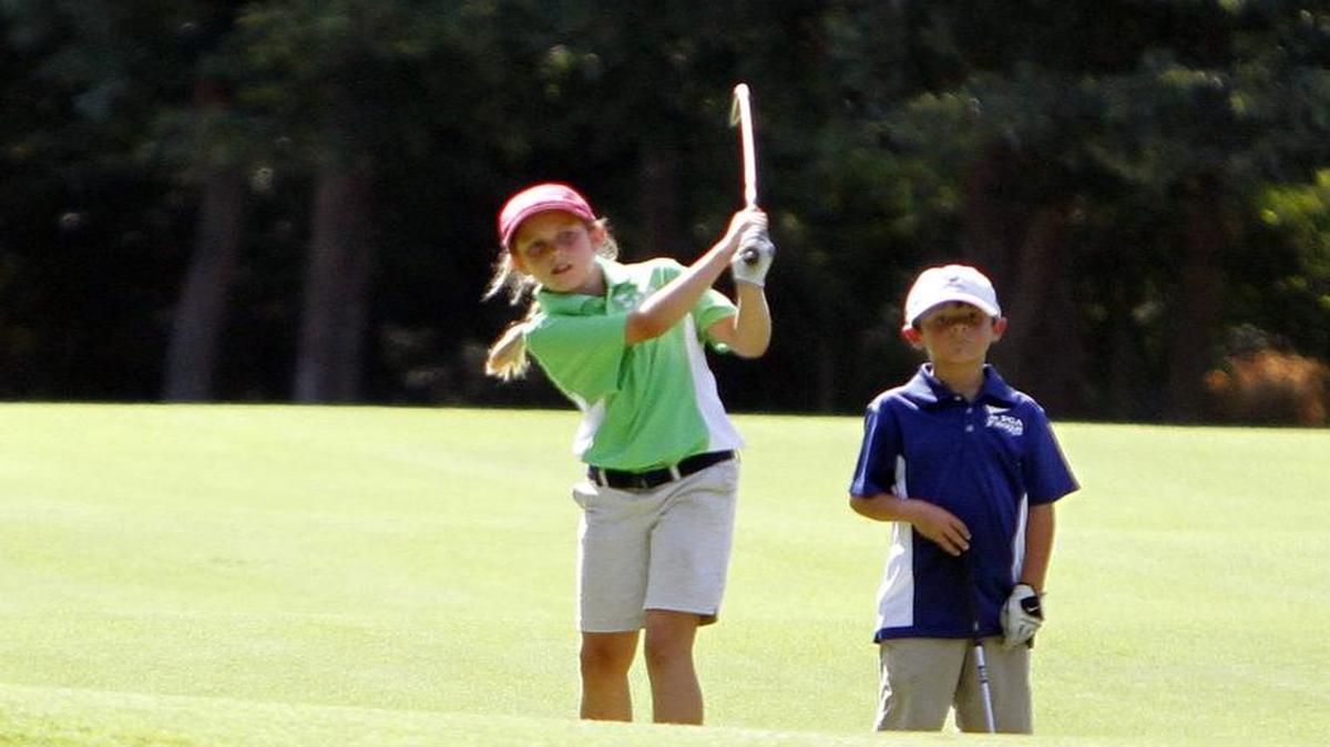 Maris Jennings makes her approach shot as Campbell McClain watches in a PGA Junior League Golf match at Wachesaw Plantation Club in July 2015. The fourth season of the team junior golf league is expected to begin in mid-June.
